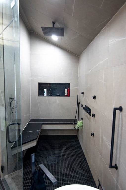 miscellaneous room featuring tile patterned floors, tile walls, and vaulted ceiling