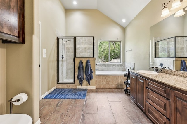 bathroom with tile patterned floors, independent shower and bath, lofted ceiling, and vanity