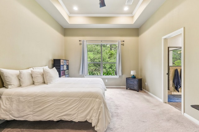 carpeted bedroom featuring a raised ceiling and ornamental molding