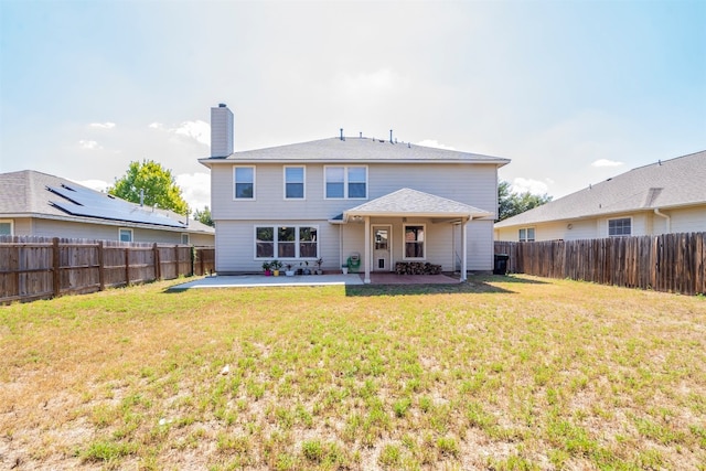 back of property with a patio area and a yard