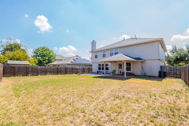 back of house featuring a patio area and a lawn