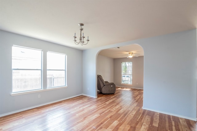 unfurnished room featuring a chandelier and light hardwood / wood-style floors