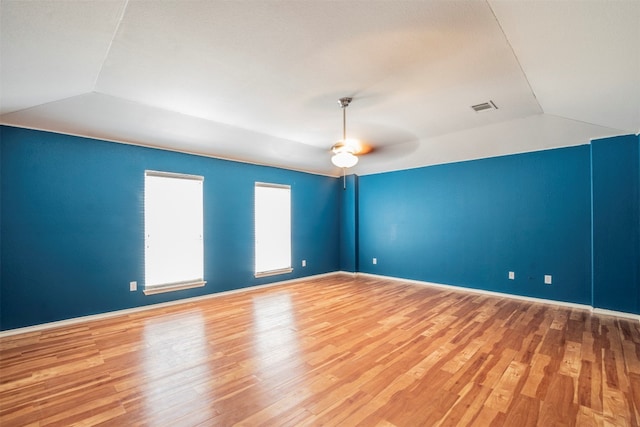 empty room featuring lofted ceiling, light hardwood / wood-style flooring, and ceiling fan