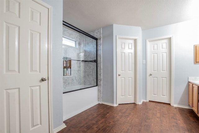 bathroom with a textured ceiling, vanity, shower / bath combination with glass door, and hardwood / wood-style flooring