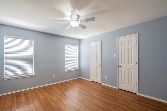 empty room with a textured ceiling, ceiling fan, and hardwood / wood-style floors