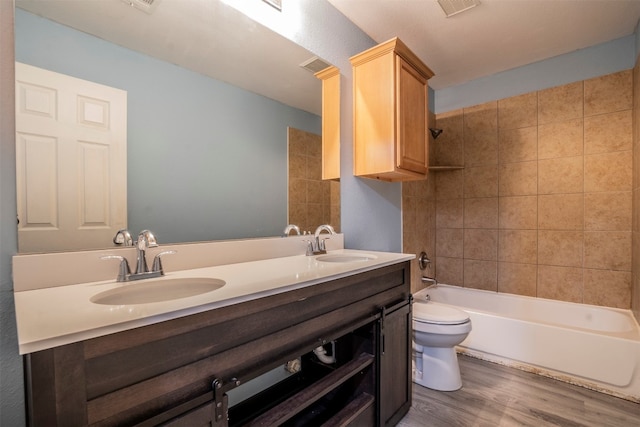 full bathroom featuring tiled shower / bath combo, vanity, toilet, and wood-type flooring