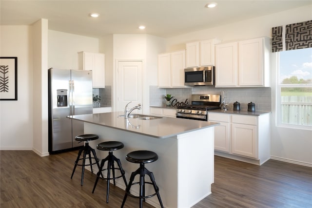 kitchen with stainless steel appliances, an island with sink, white cabinetry, and sink