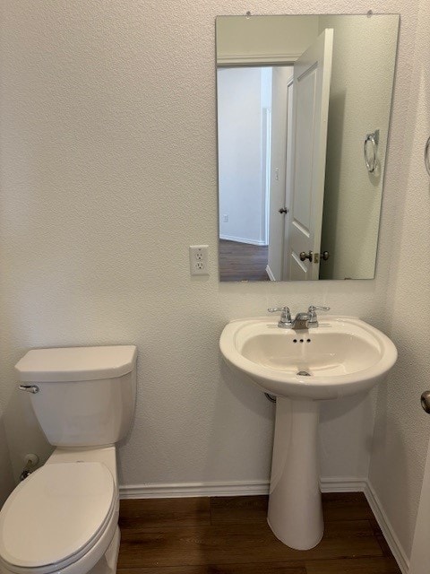 bathroom featuring wood-type flooring and toilet