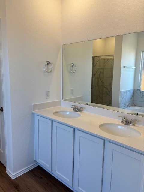 bathroom with wood-type flooring, vanity, and a washtub