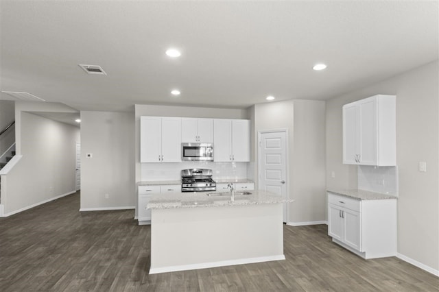 kitchen featuring appliances with stainless steel finishes, white cabinets, and light stone countertops