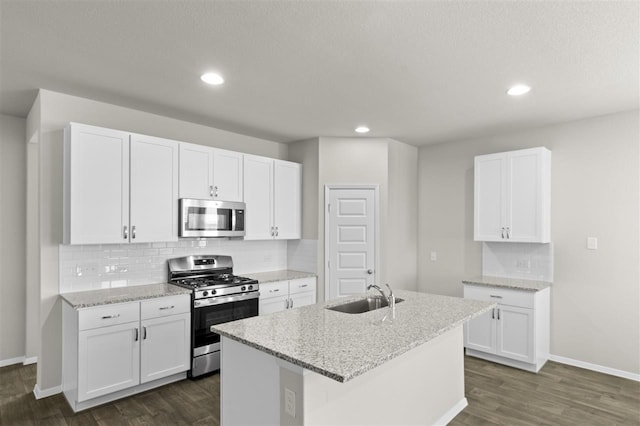 kitchen featuring sink, stainless steel appliances, an island with sink, and white cabinets