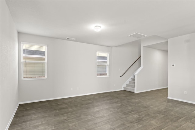 spare room featuring dark wood-type flooring and plenty of natural light