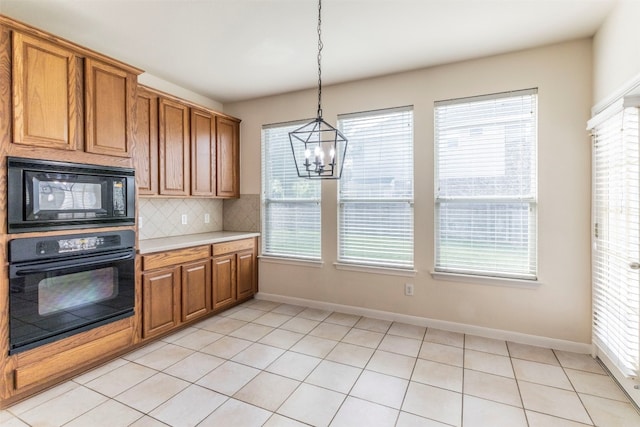 kitchen with black appliances, a wealth of natural light, and decorative light fixtures