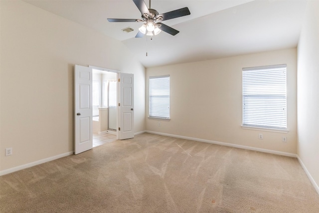 carpeted spare room featuring lofted ceiling and ceiling fan