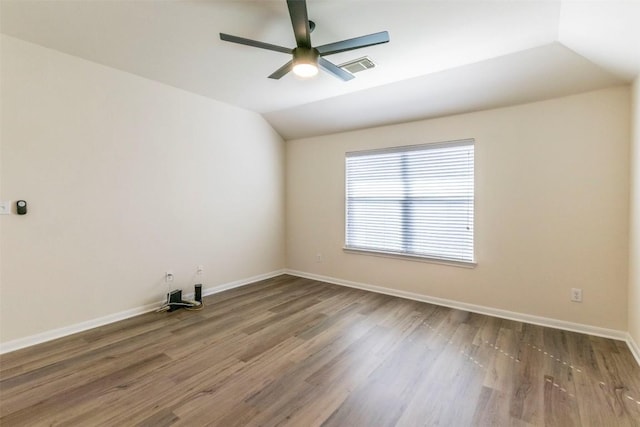 empty room with visible vents, lofted ceiling, wood finished floors, baseboards, and a ceiling fan