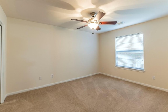 unfurnished room featuring baseboards, visible vents, ceiling fan, and light colored carpet
