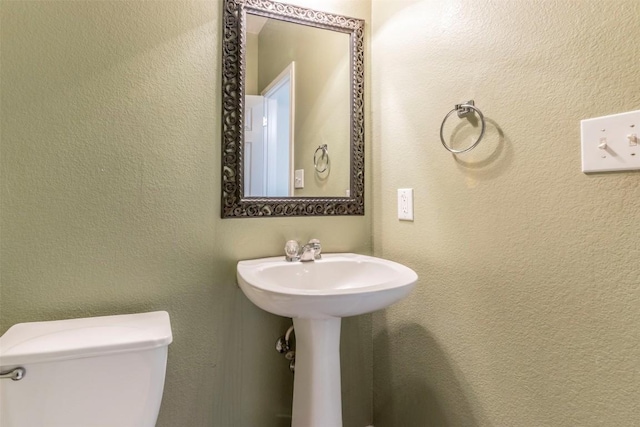 half bathroom featuring a sink and toilet