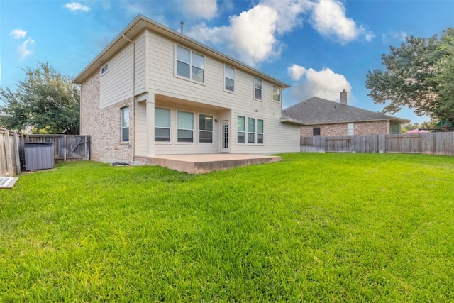 rear view of house with a lawn, a patio, and a fenced backyard