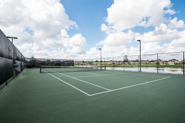 view of tennis court featuring a water view