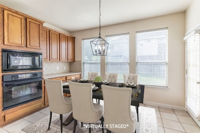 dining room with an inviting chandelier, light tile patterned floors, and a wealth of natural light