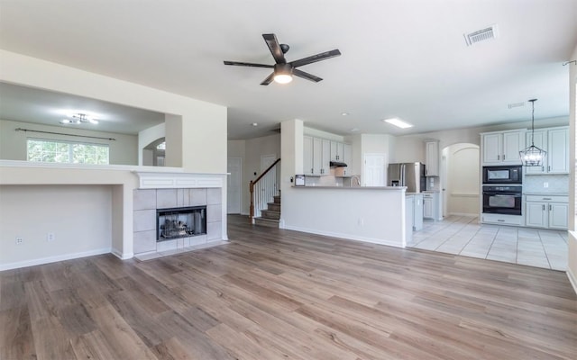 1001 Winding Creek Pl, Round Rock, TX 78665 - unfurnished living room featuring ceiling fan, light wood-type flooring, a fireplace, and baseboards