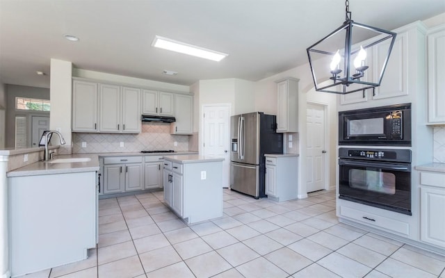 1001 Winding Creek Pl, Round Rock, TX 78665 - kitchen featuring black appliances, a sink, under cabinet range hood, a chandelier, and tasteful backsplash