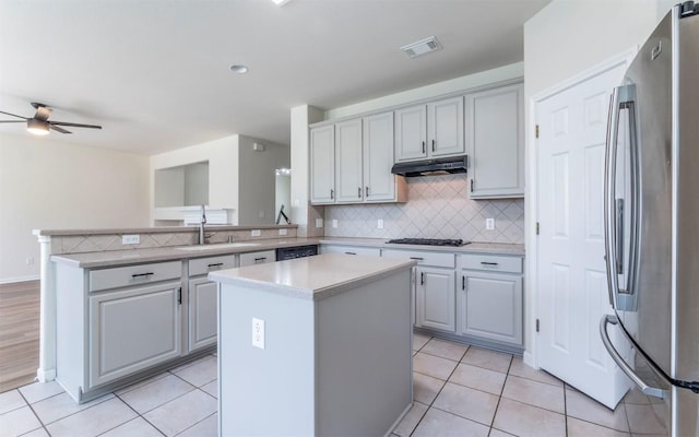 1001 Winding Creek Pl, Round Rock, TX 78665 - kitchen with freestanding refrigerator, under cabinet range hood, a sink, decorative backsplash, and light countertops