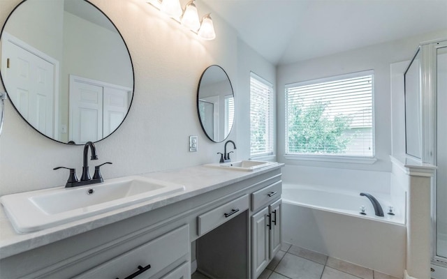 1001 Winding Creek Pl, Round Rock, TX 78665 - bathroom featuring a garden tub, double vanity, and tile patterned floors