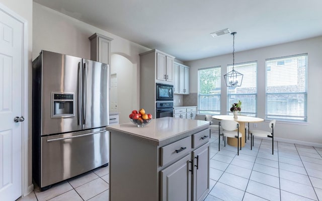 1001 Winding Creek Pl, Round Rock, TX 78665 - kitchen featuring black appliances, light countertops, light tile patterned flooring, hanging light fixtures, and a center island