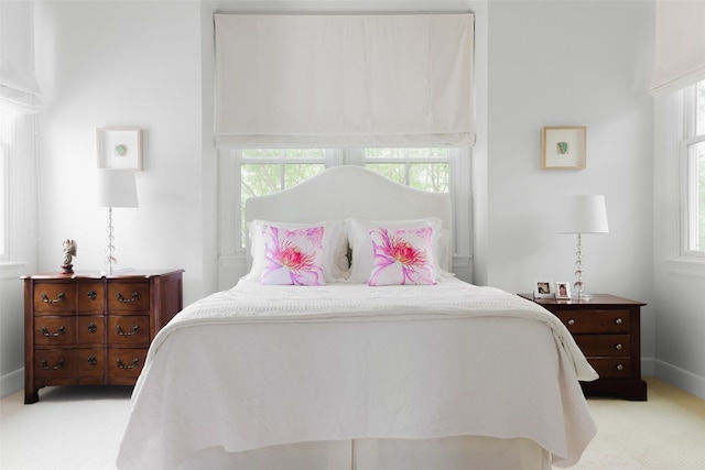 bedroom featuring multiple windows and light colored carpet