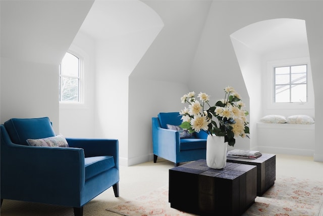 sitting room featuring a wealth of natural light, light carpet, and lofted ceiling