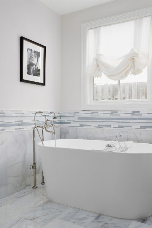 bathroom featuring tile walls and a bathing tub