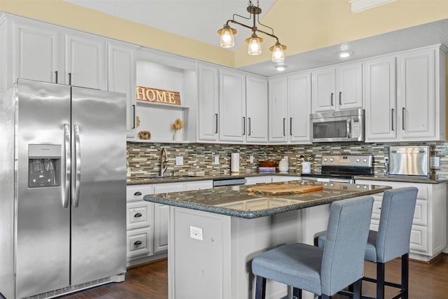 kitchen featuring a center island, white cabinetry, stainless steel appliances, and dark hardwood / wood-style floors