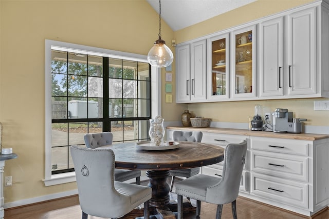 dining room with vaulted ceiling and hardwood / wood-style flooring