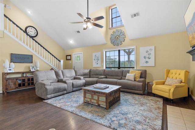 living room with dark wood-type flooring, ceiling fan, and high vaulted ceiling