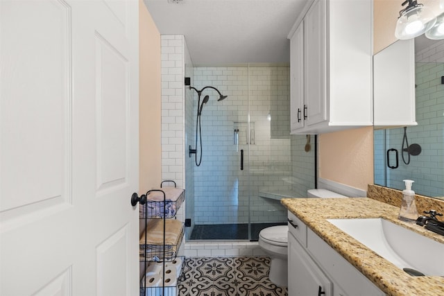 bathroom with toilet, tile patterned flooring, a shower with door, vanity, and a textured ceiling