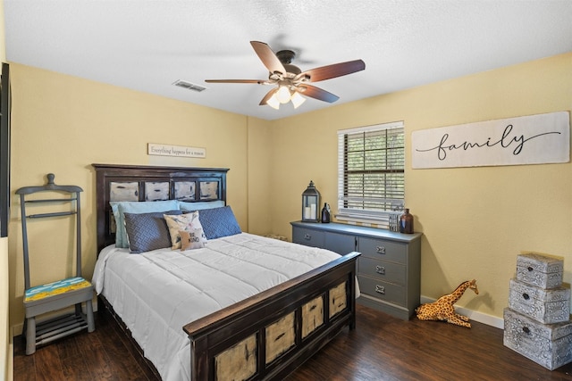 bedroom featuring ceiling fan, dark hardwood / wood-style floors, and a textured ceiling