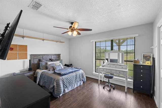 bedroom with a textured ceiling, ceiling fan, and dark hardwood / wood-style floors