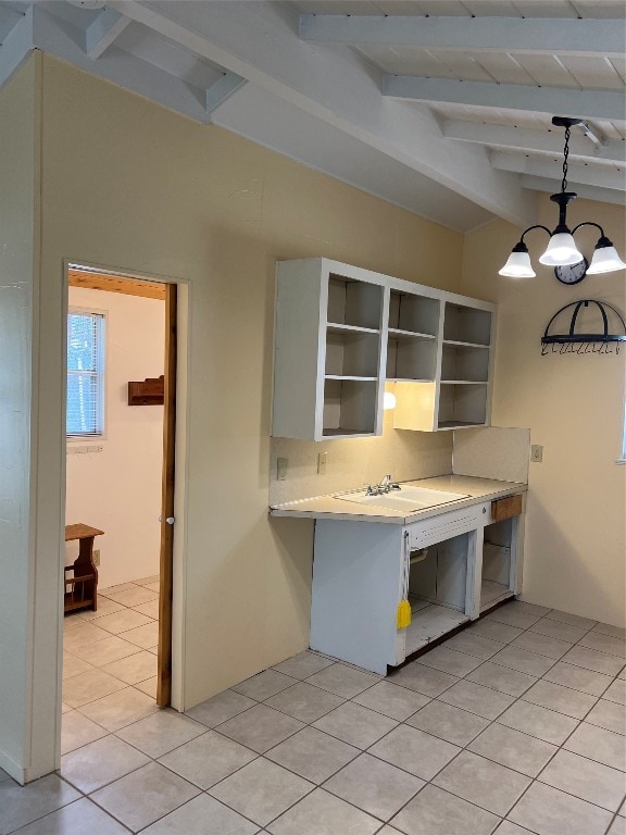 kitchen featuring pendant lighting, beam ceiling, backsplash, and light tile patterned flooring