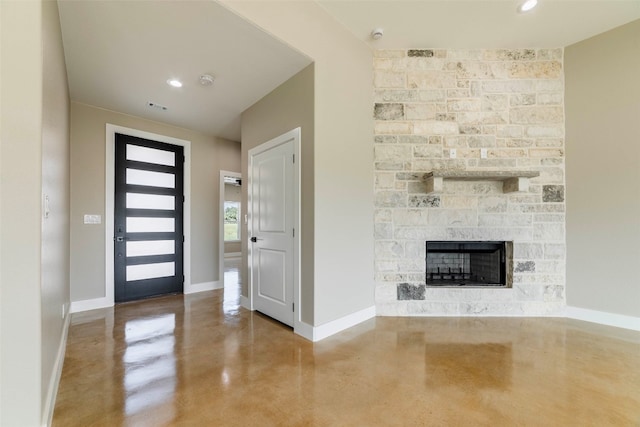 foyer entrance with a fireplace and concrete floors