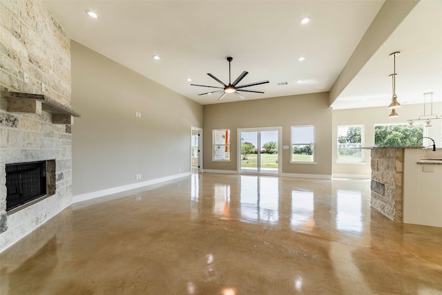 unfurnished living room featuring ceiling fan, a fireplace, and sink