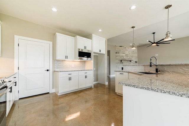 kitchen featuring white cabinets, ceiling fan, appliances with stainless steel finishes, and decorative light fixtures