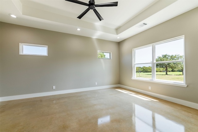 spare room with ceiling fan and a raised ceiling