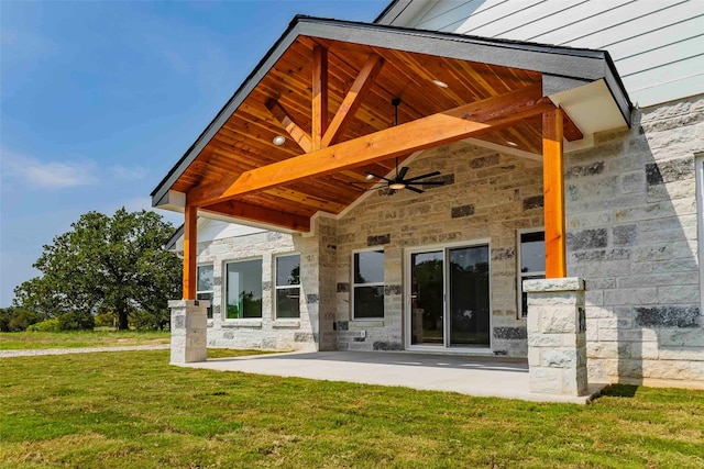 rear view of house featuring ceiling fan, a patio area, and a yard