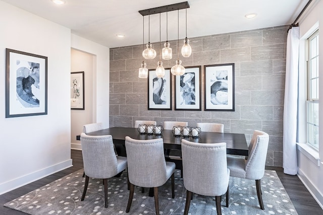 dining area with a healthy amount of sunlight, tile walls, and dark wood-type flooring