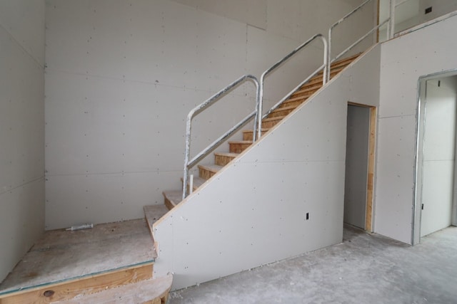 staircase featuring concrete flooring