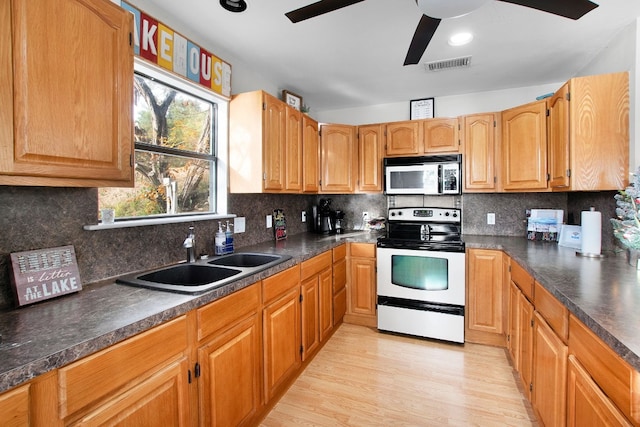 kitchen featuring white electric range, light hardwood / wood-style flooring, sink, ceiling fan, and decorative backsplash