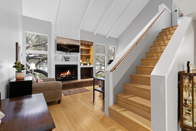 living room with vaulted ceiling with beams and hardwood / wood-style flooring