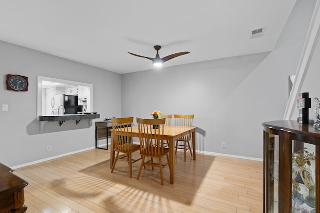 dining space with light hardwood / wood-style flooring and ceiling fan