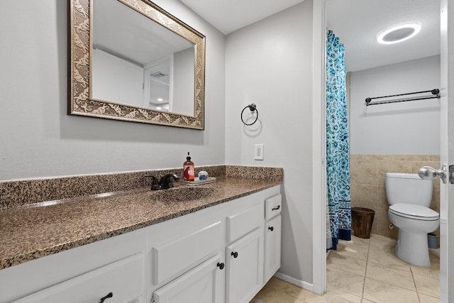 bathroom featuring vanity, tile walls, toilet, and tile patterned floors